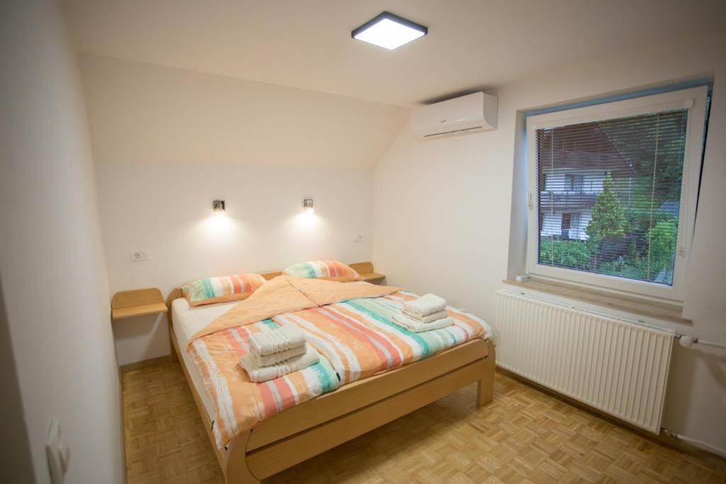 a small bedroom with a bed and a window at APARTMAJI HUBI in Bled
