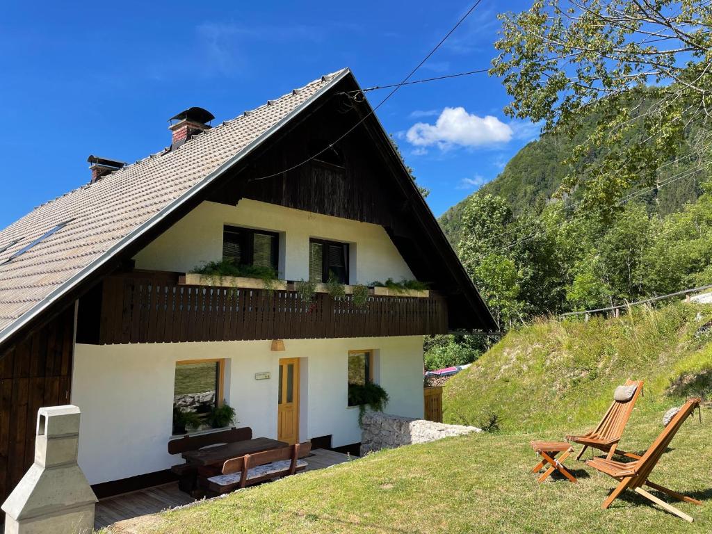 un cottage dans les montagnes avec 2 chaises dans l'établissement Apartma Korošec, à Srednja Vas v Bohinju