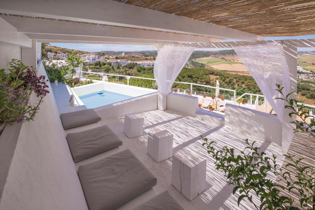 a patio with a plunge pool and white furniture at Casa Boutique Encalada in Vejer de la Frontera