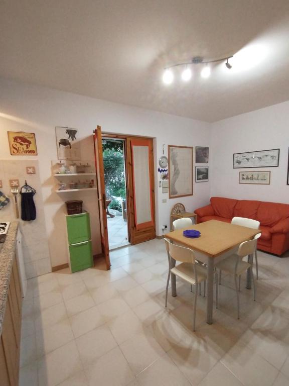salon ze stołem i czerwoną kanapą w obiekcie casa luisa3br w mieście Cala Gonone