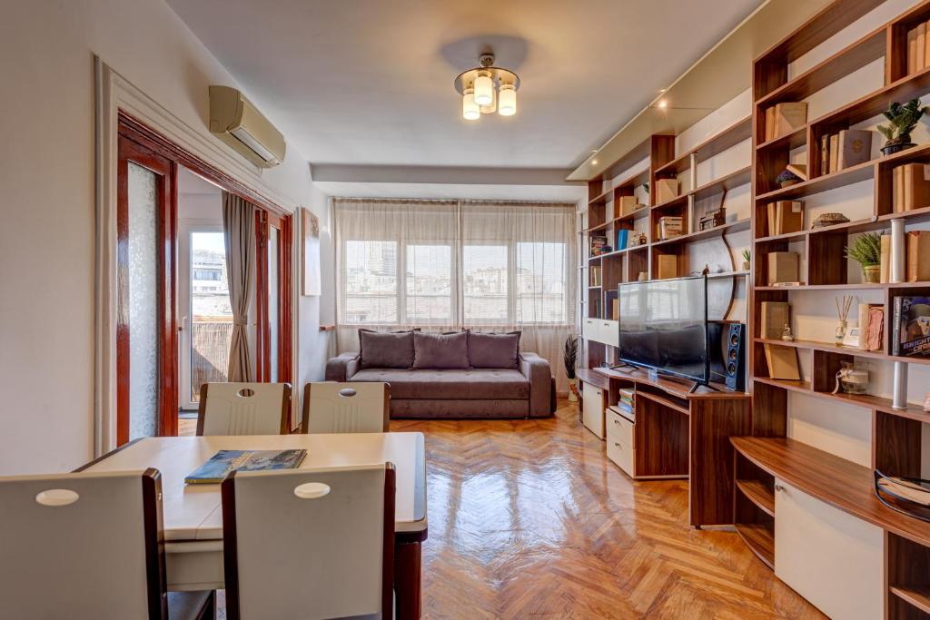 a living room with a table and a couch at Old Town Home Library in Bucharest