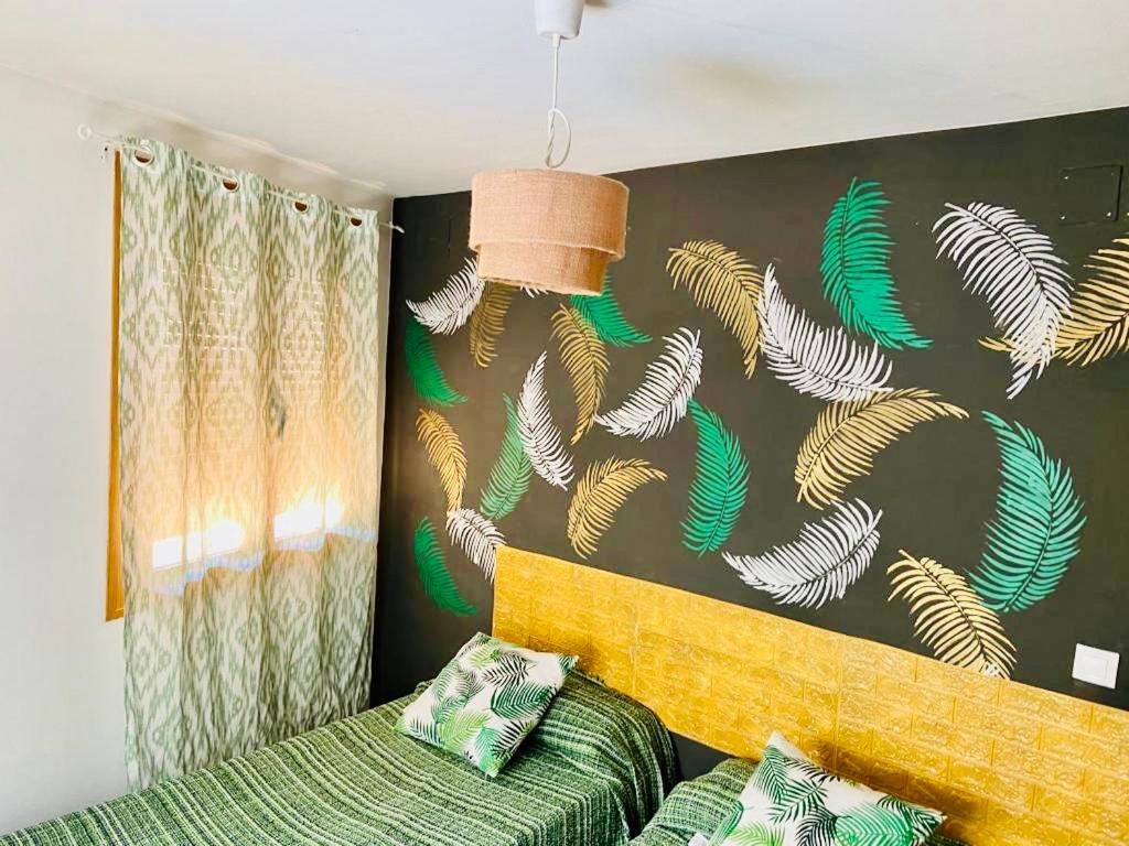 アロヨ・フリオにあるEl Ríoの緑のベッドと魚の柄の壁が備わるベッドルーム1室