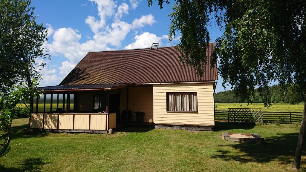 ein kleines Haus inmitten eines Feldes in der Unterkunft Pirmie Zaļmeži in Jūrkalne