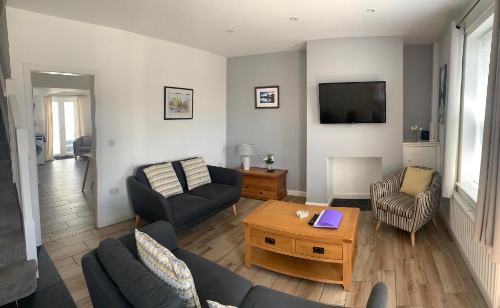 een woonkamer met een bank en een tafel bij Taitwt 3 in Caernarfon