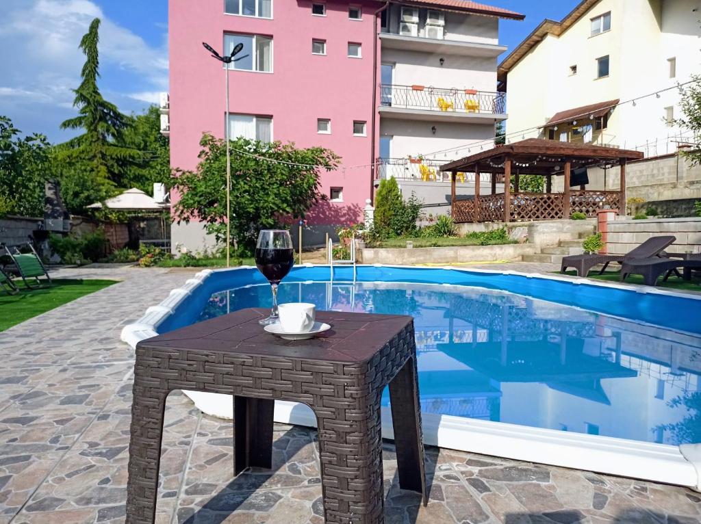 a table with a glass of wine next to a pool at Guest House 51 in Kranevo