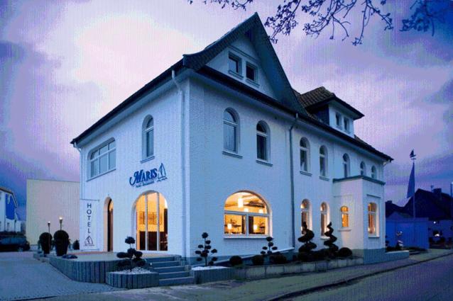 a large white building with a store on a street at Maris Hotel in Steinhude