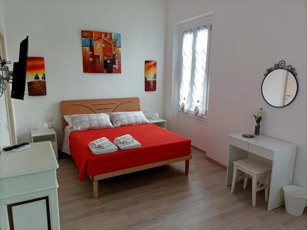 una camera con letto rosso e specchio di Affittacamere Il Chiostrino Guest House a Firenze