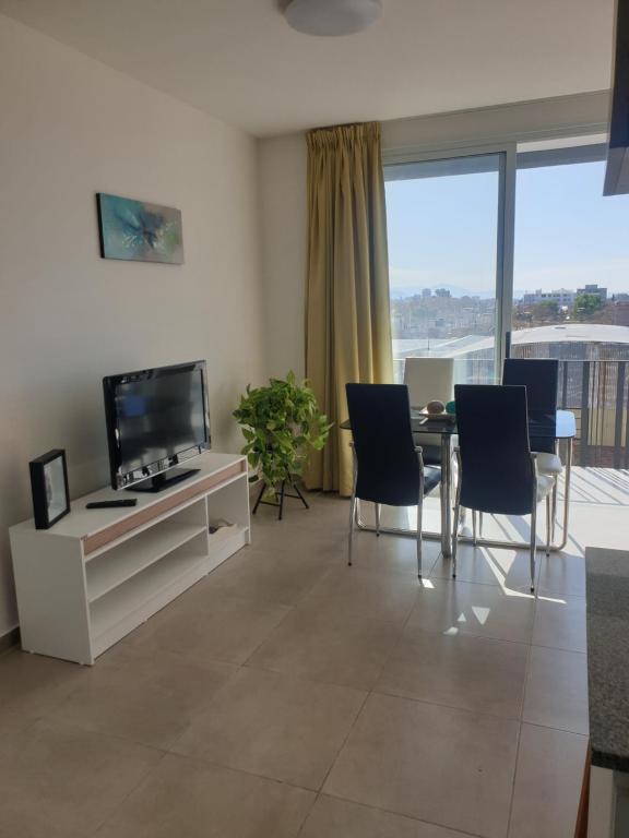 a living room with a tv and a table and chairs at Departamento Godoy Cruz in Godoy Cruz