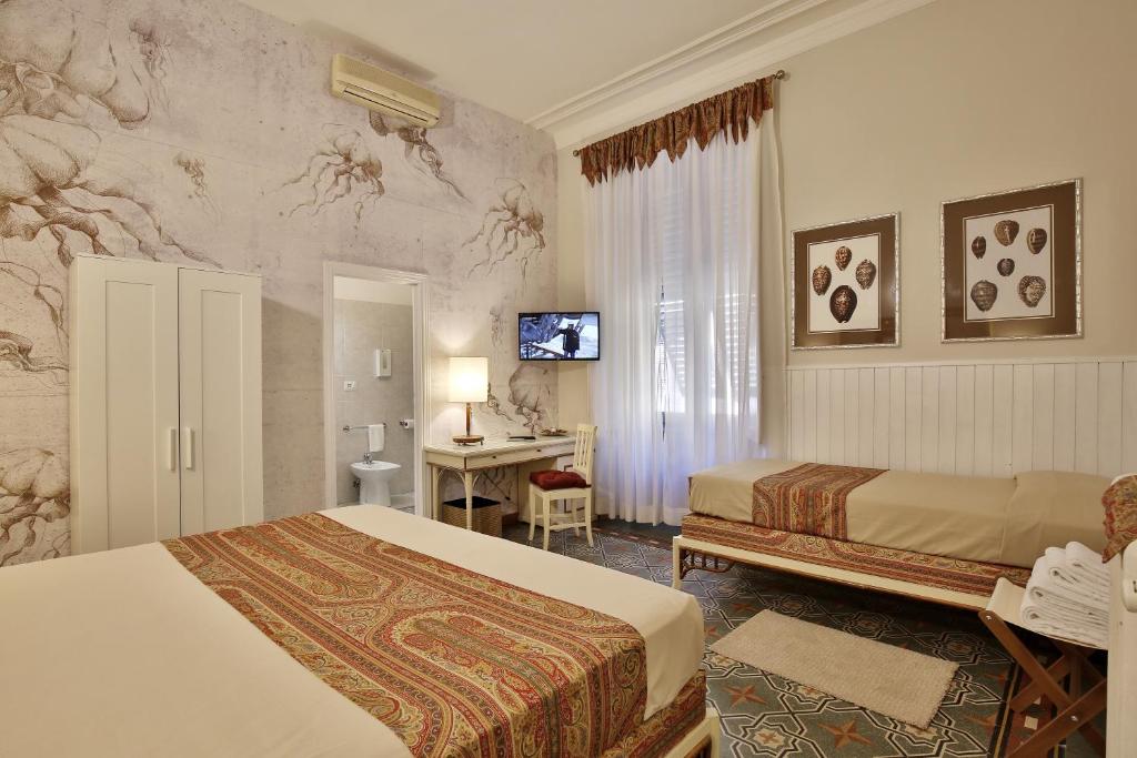 a hotel room with two beds and a desk at MADAMA GUEST HOUSE in Florence