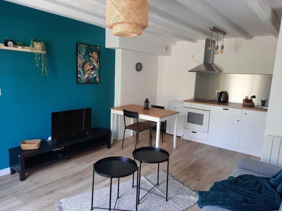 a kitchen with a table and chairs in a room at Appartement RDC-Loire à vélo-Proche Saumur in Parnay