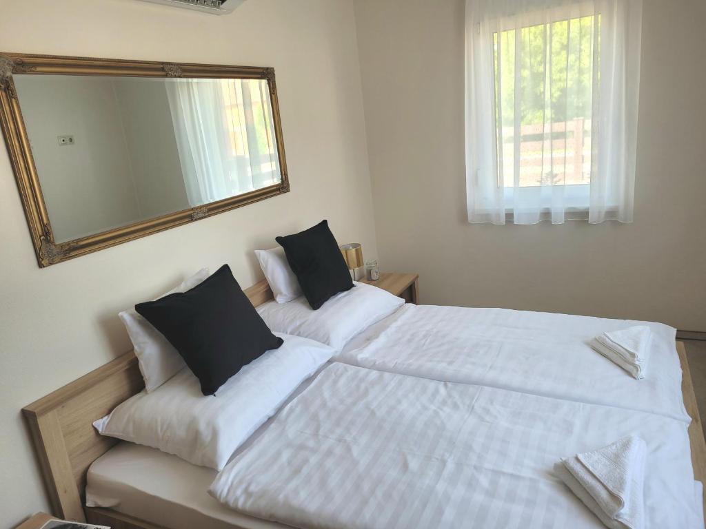 A bed or beds in a room at Silver Lodge Vendégház Egerszalók
