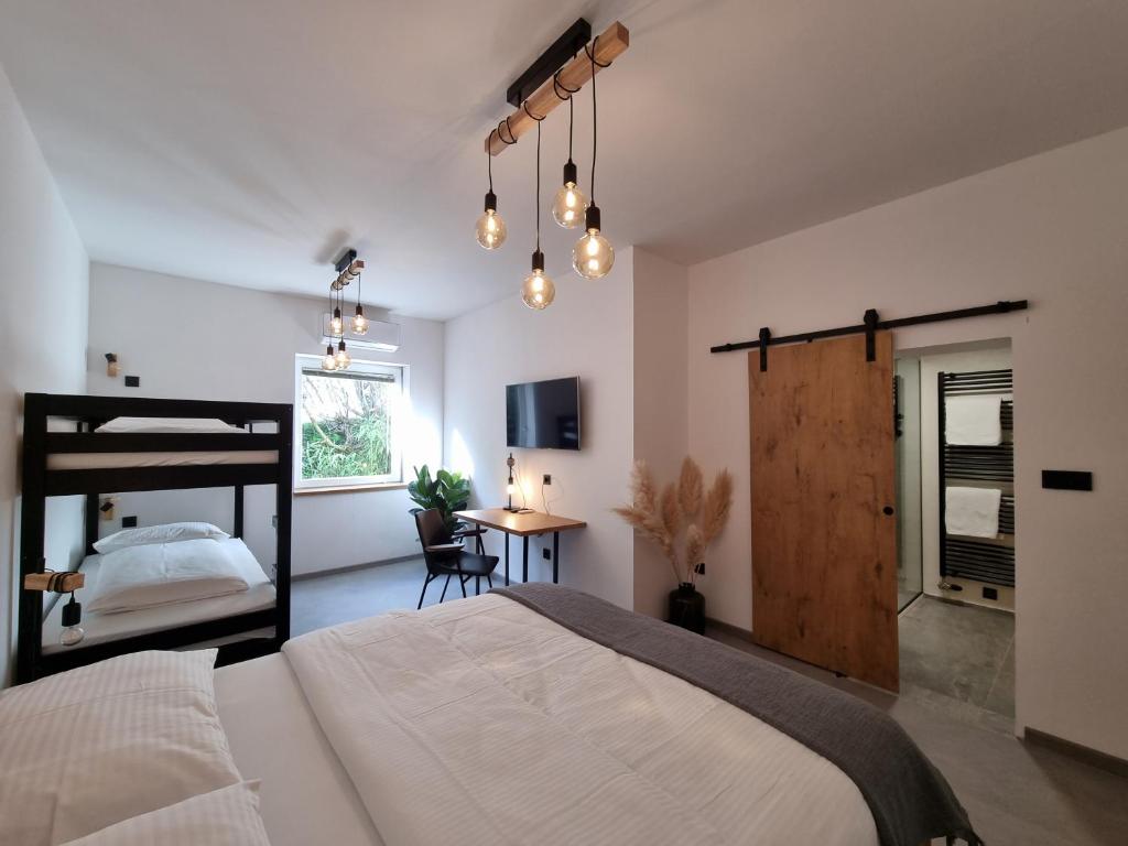 ein Schlafzimmer mit einem großen Bett und einem Tisch in der Unterkunft Bistro & Rooms pri Karlu - ex Hiša Budja in Maribor