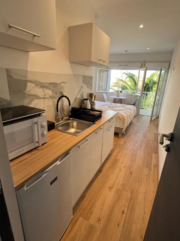 a kitchen with a sink and a bed in a room at Home Place Apartments - Gujan Arcachon in Gujan-Mestras