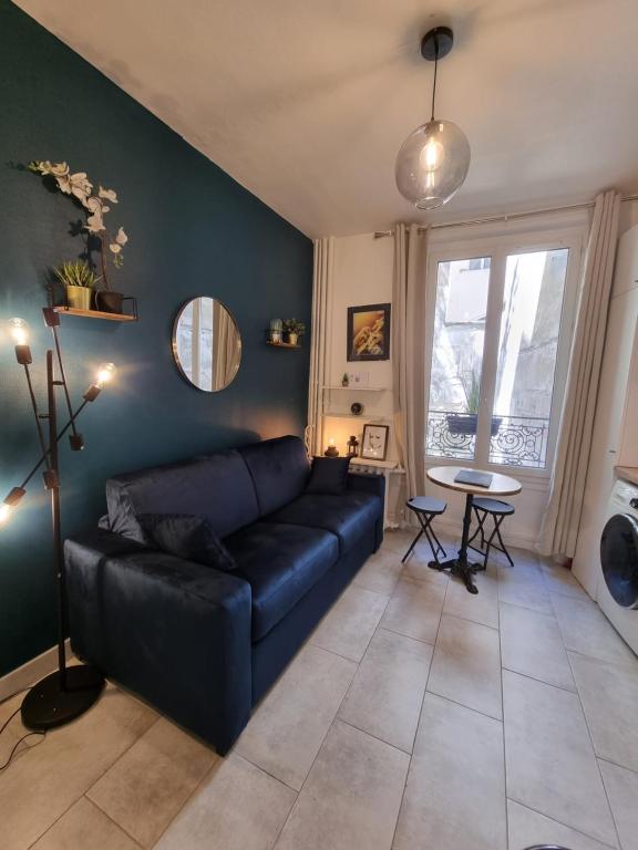 a living room with a black couch and a table at Cosy studio in heart of Montmartre in Paris