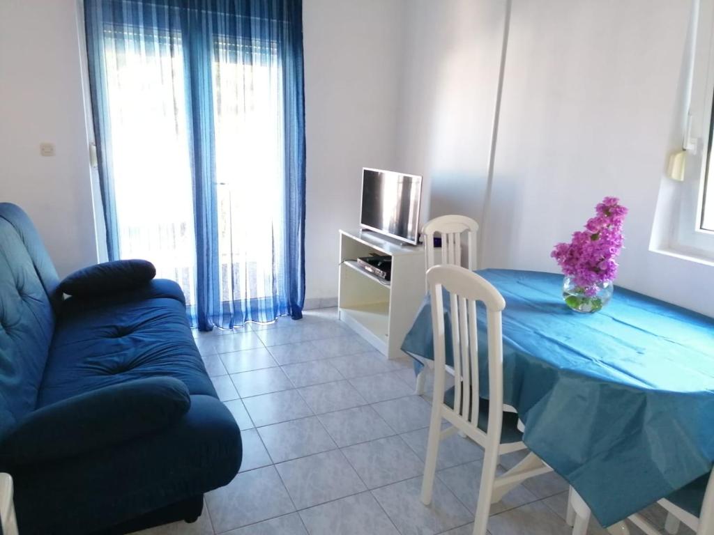 a living room with a blue table and a couch at Apartment Sun in Klek