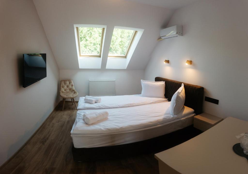 a small bedroom with a bed with a window at Vila Noblesse in Sovata