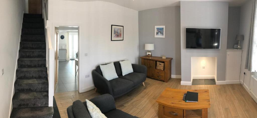 a living room with a couch and a tv at CAERNARFON Quality Townhouse in Caernarfon