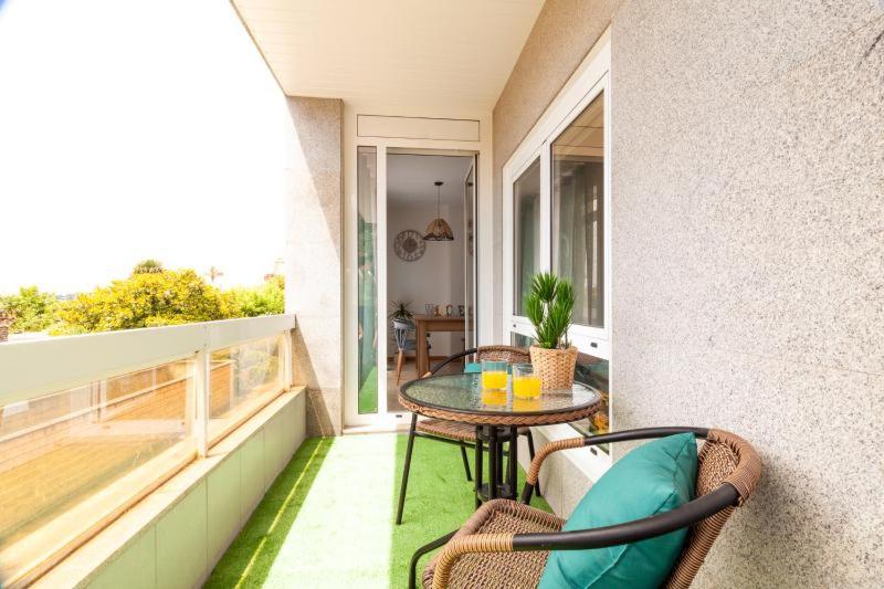 eine Terrasse mit einem Tisch und Stühlen auf dem Balkon in der Unterkunft Samil primera línea de playa in Vigo