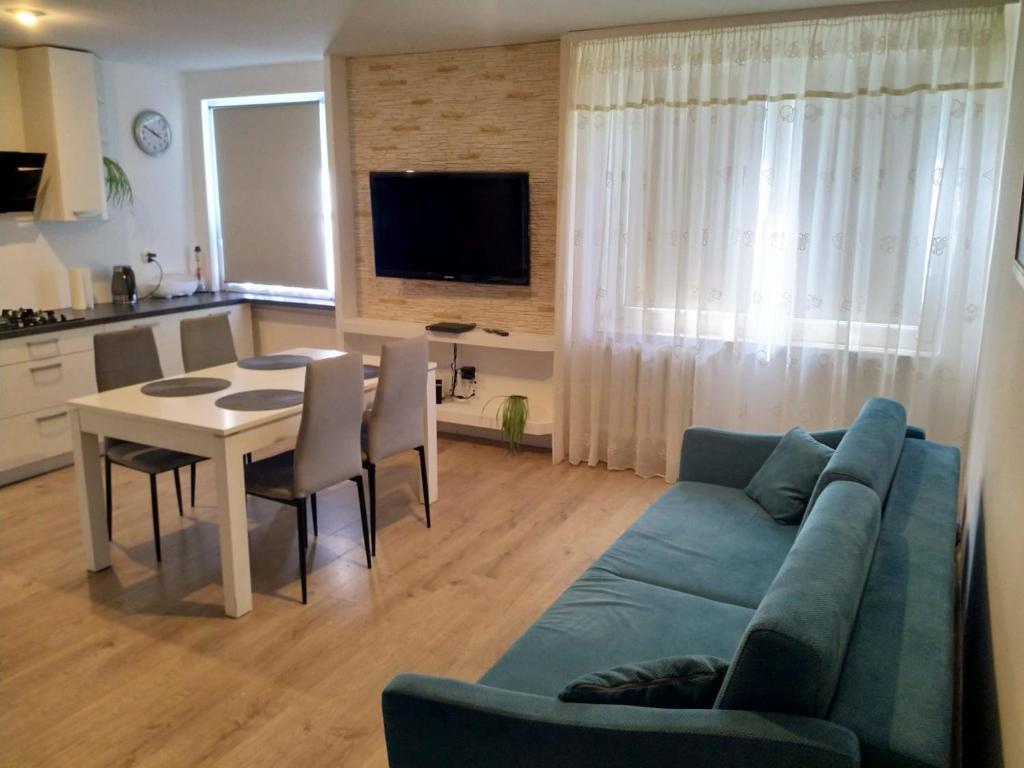sala de estar con sofá azul y mesa en Apartament Blisko Plaży, en Gdansk