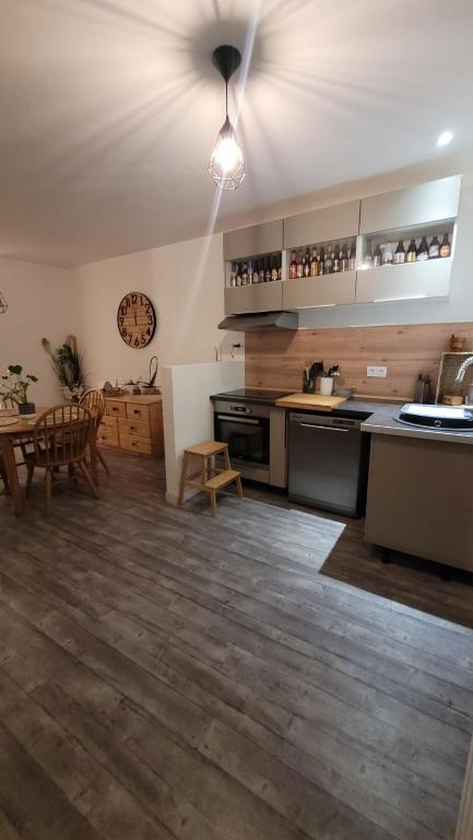 une cuisine avec une table et un ventilateur de plafond dans l'établissement Là Casa 1908, à Le Porge