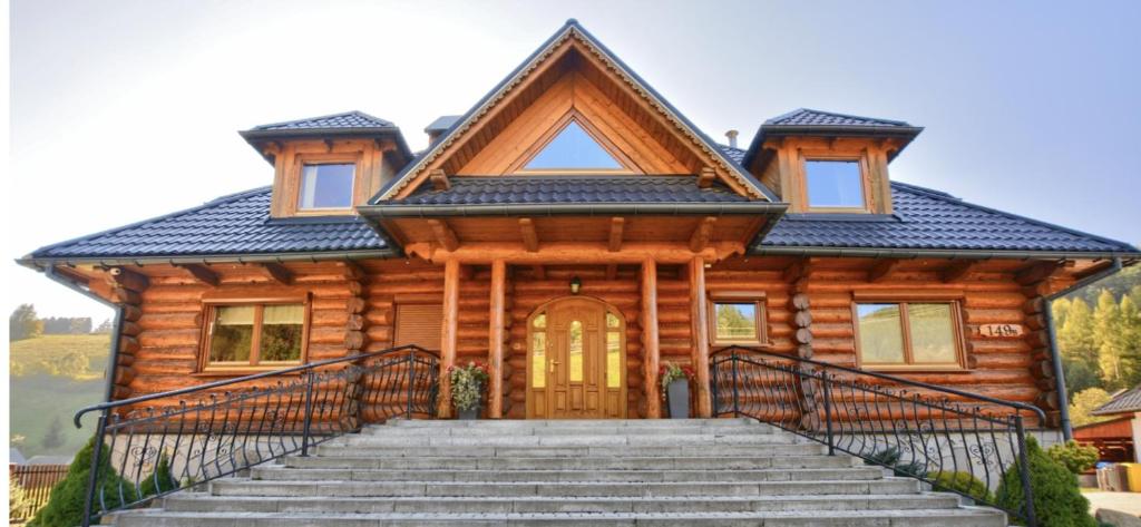 a log cabin with stairs in front of it at Góralski Sen in Ochotnica Górna