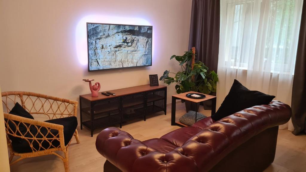a living room with a leather couch and a table at Your Space in Jurmala in Jūrmala
