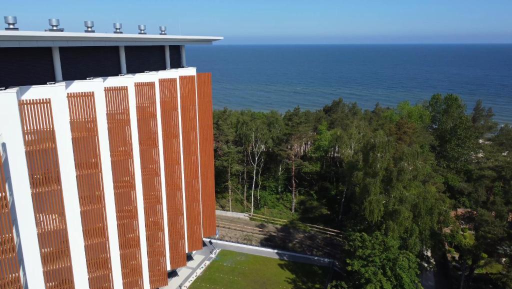 an office building with the ocean in the background at Apartamenty Pinea in Pobierowo