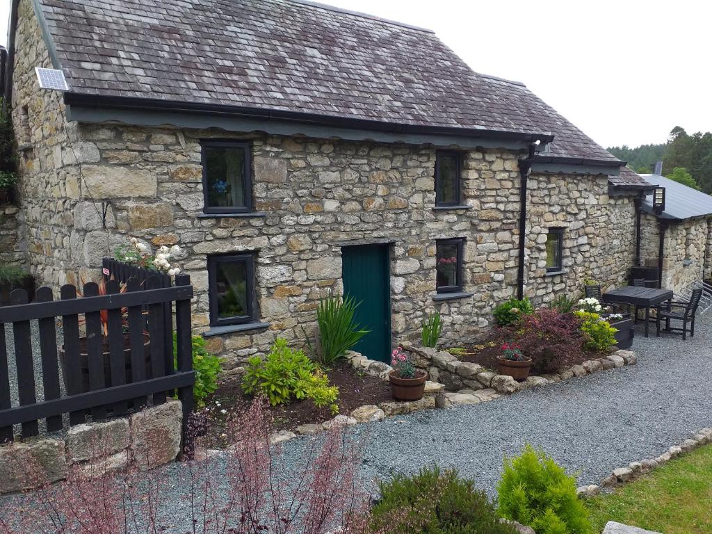 una casa in pietra con una porta verde e alcune piante di St Mullins Camping a Saint Mullins