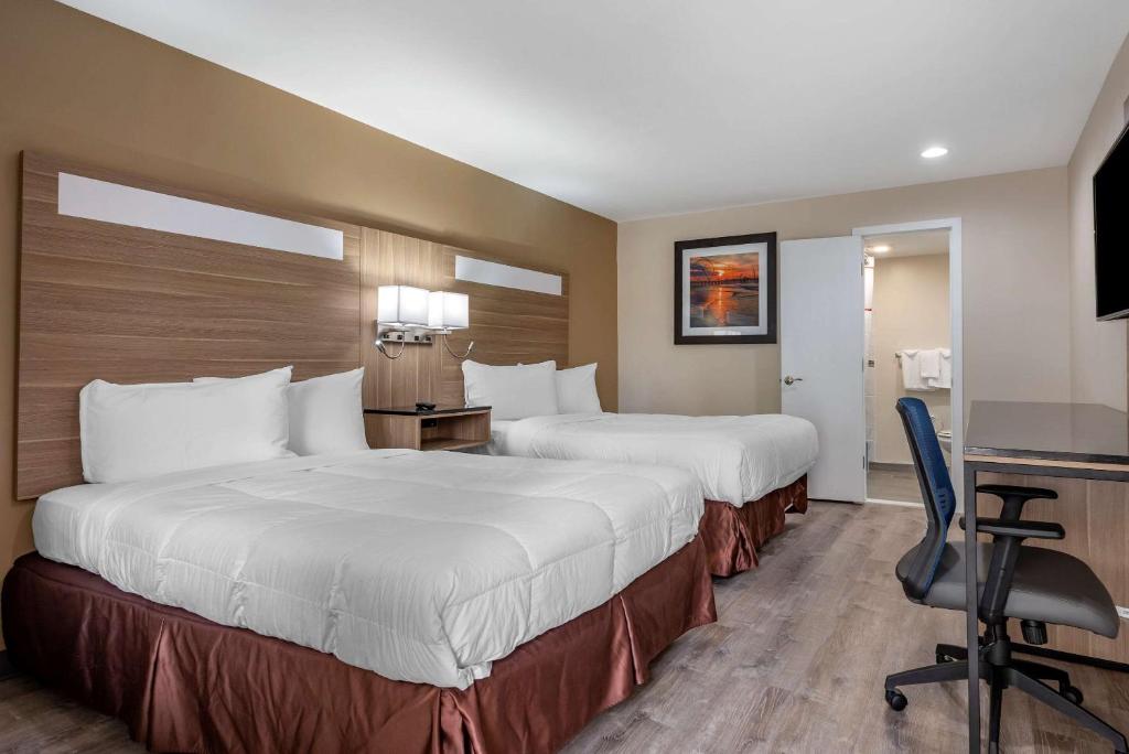 a hotel room with two beds and a desk at Rodeway Inn Oceanview in Atlantic City