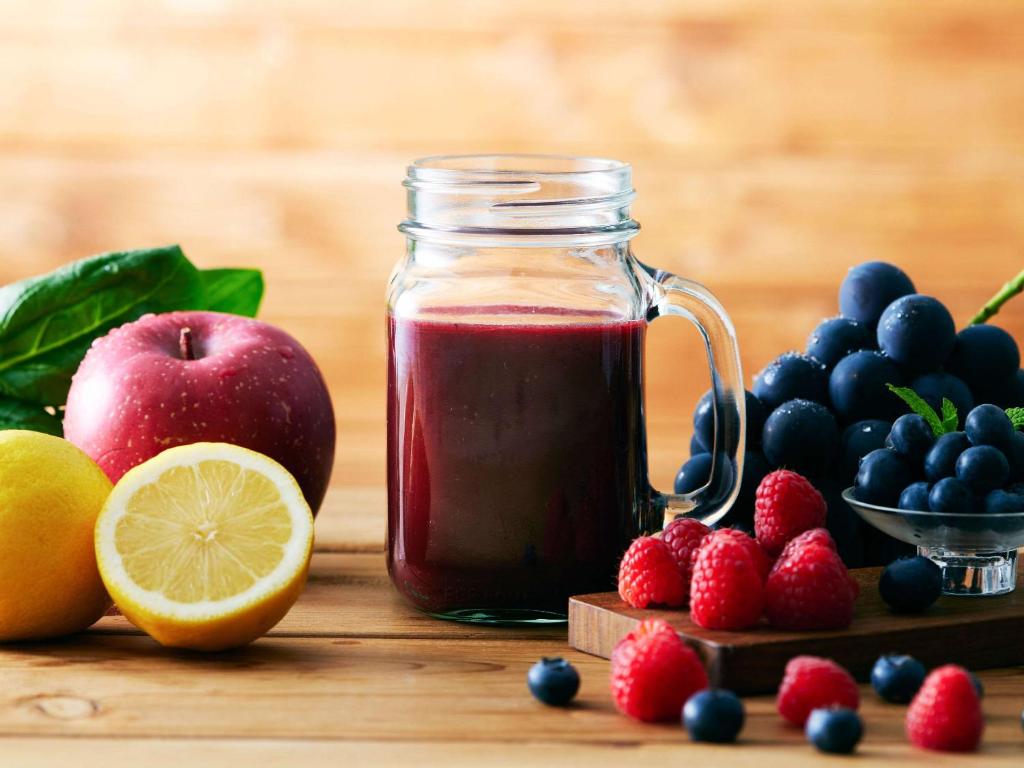 a jar of jam next to fruits and berries at Comfort Hotel Central International Airport in Tokoname