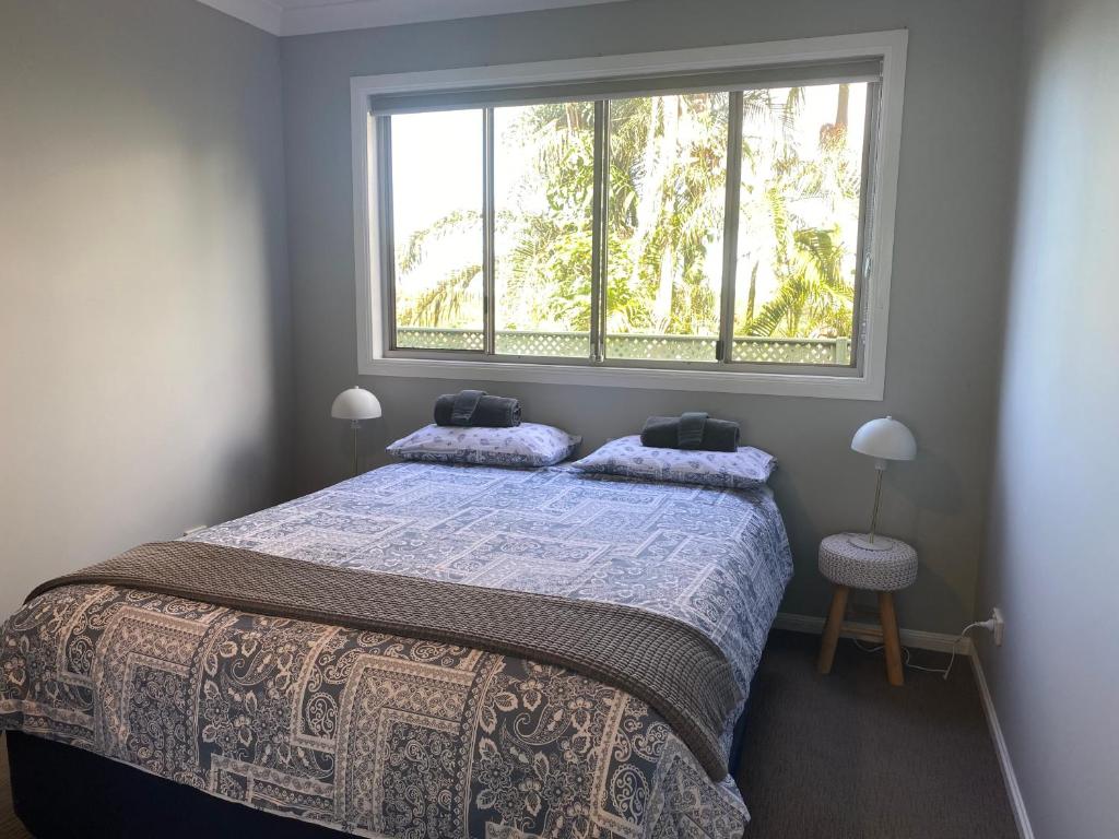 1 dormitorio con 1 cama y ventana grande en Central Oasis en Coffs Harbour