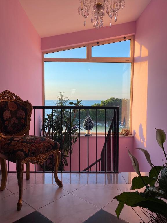 a room with a chair and a large window at Hotel Scilla in Scilla