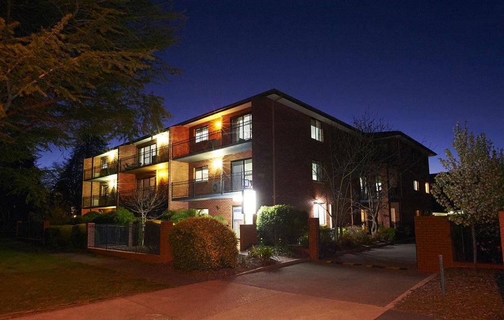 a building with lights on in front of it at night at Oxley Court Serviced Apartments in Canberra