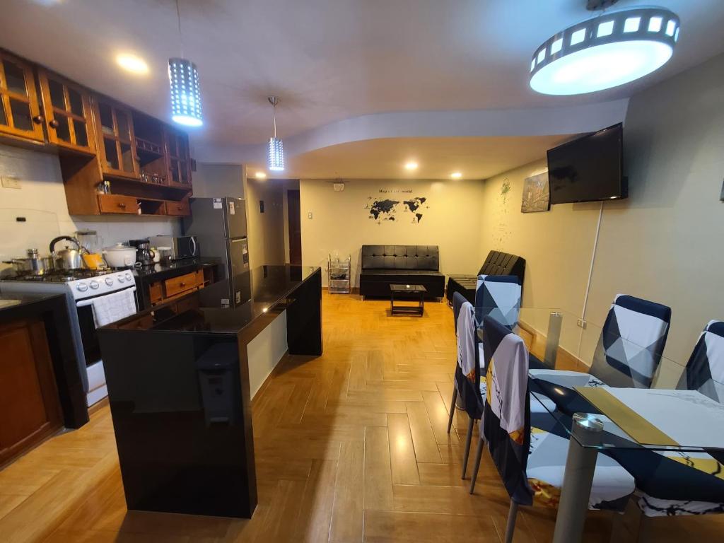 a kitchen and living room with a table and chairs at Samana Wasi, Lugar encantador en Cusco in Cusco