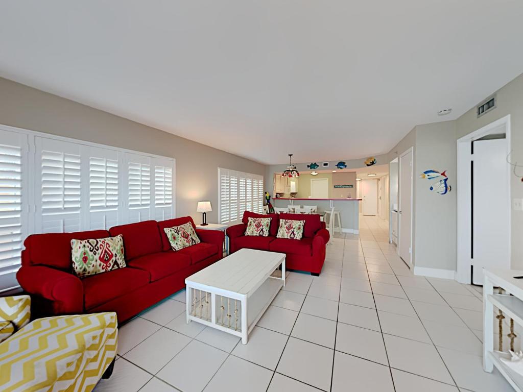 sala de estar con sofá rojo y mesa en Sea Oats #201, en Fort Walton Beach