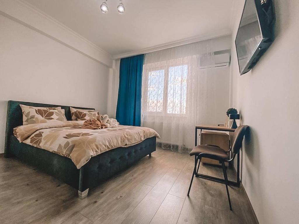 ein Schlafzimmer mit einem Bett, einem Stuhl und einem Schreibtisch in der Unterkunft Lovely Apartment in Sectorul Botanica