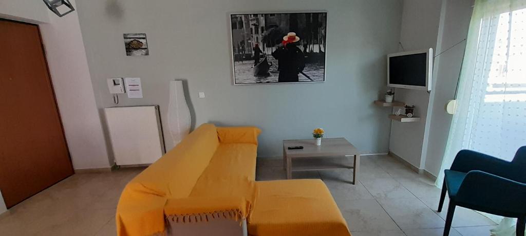 a living room with a yellow couch and a table at Dimos Sunny & Luxury Central House !!! in Perea