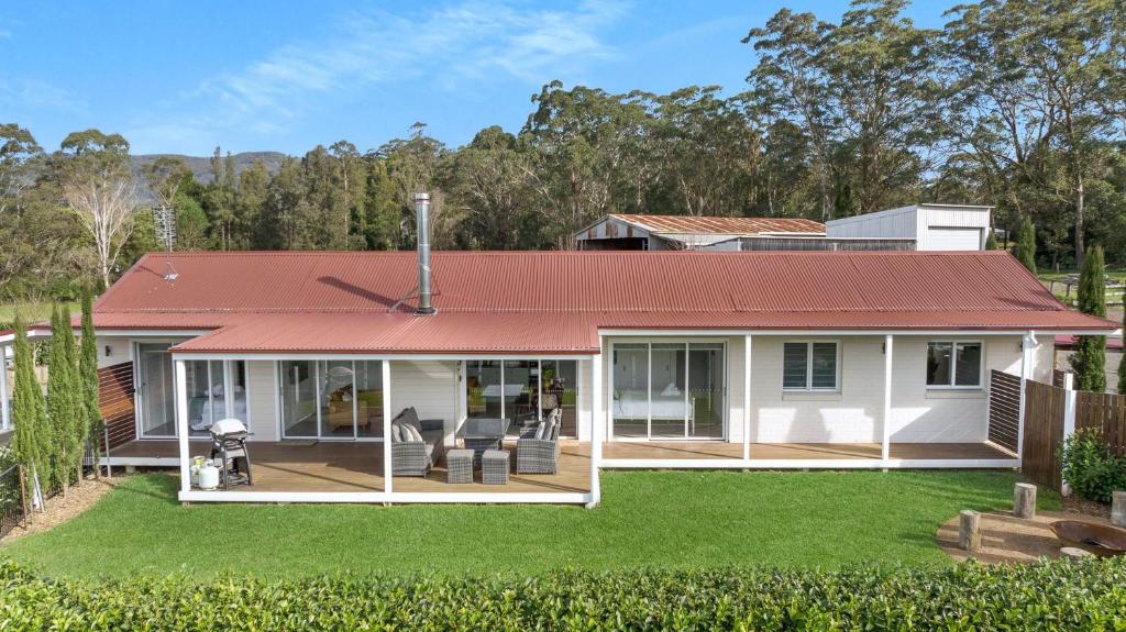 una casa con tetto rosso e un cortile di The Dairy Sojourn Kangaroo Valley a Kangaroo Valley