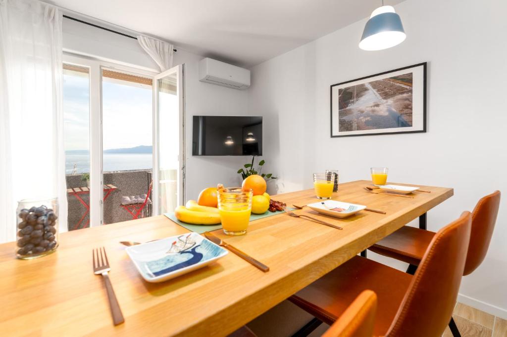 uma sala de jantar com uma mesa de madeira com cadeiras laranja em Port em Rijeka