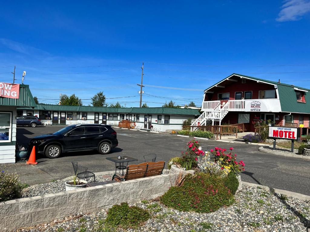 een auto geparkeerd op een parkeerplaats naast een gebouw bij Great House Motel in Sequim