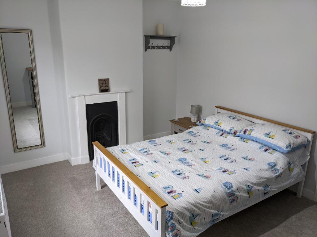 Schlafzimmer mit einem Bett, einem Spiegel und einem Spiegel in der Unterkunft Ladybird Cottage in Weymouth