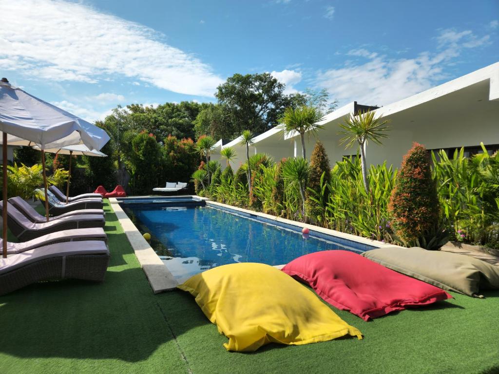 two pillows on the ground next to a swimming pool at Jago Gili Air in Gili Islands