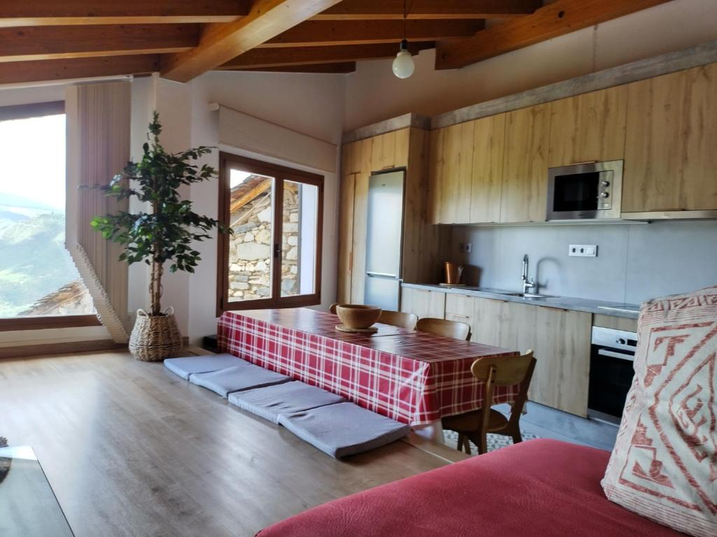 eine Küche mit einem Tisch in der Mitte eines Zimmers in der Unterkunft Casa rural con vistas en el corazón del Pirineo in Los Molinos
