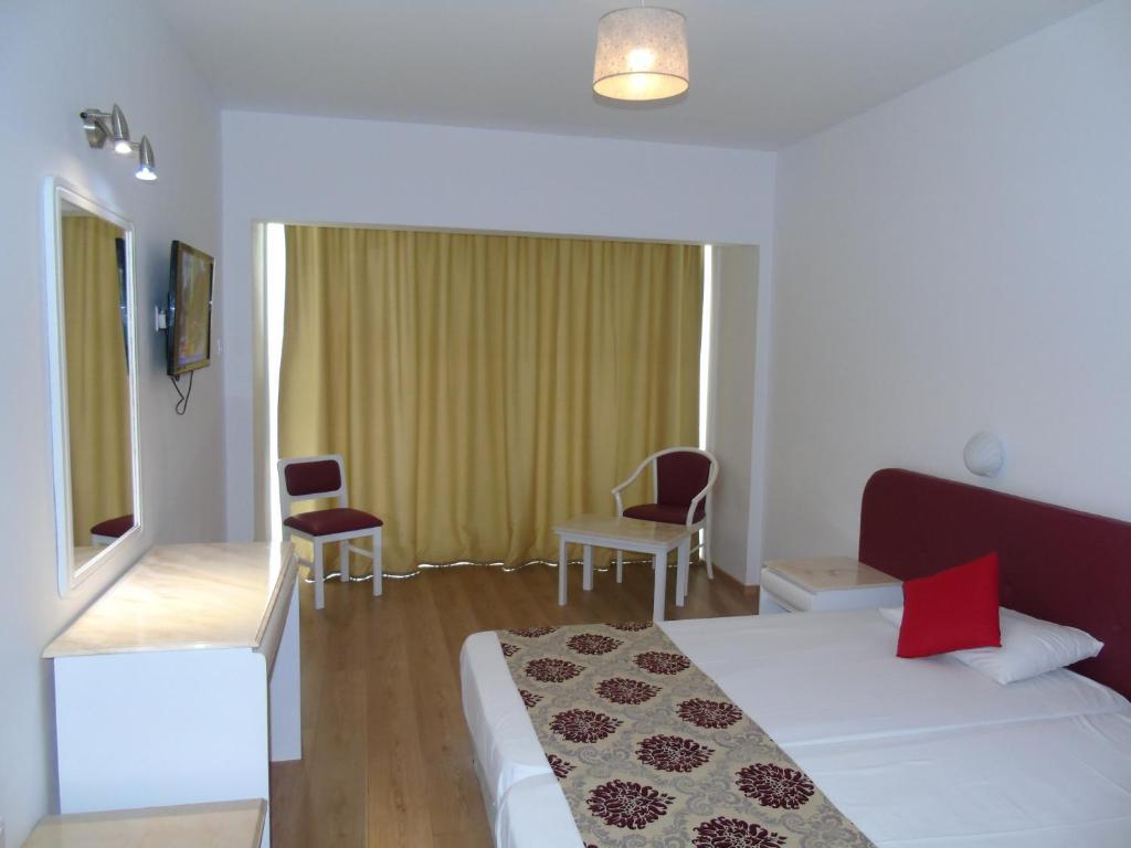 a hotel room with a bed and a table and chairs at Corfu Hotel in Ayia Napa