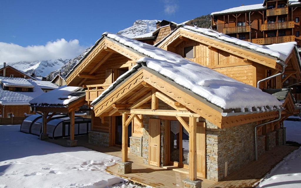 レ・デュー・アルプにあるOdalys Chalet Prestige Lodgeの屋根に雪が積もった丸太キャビン