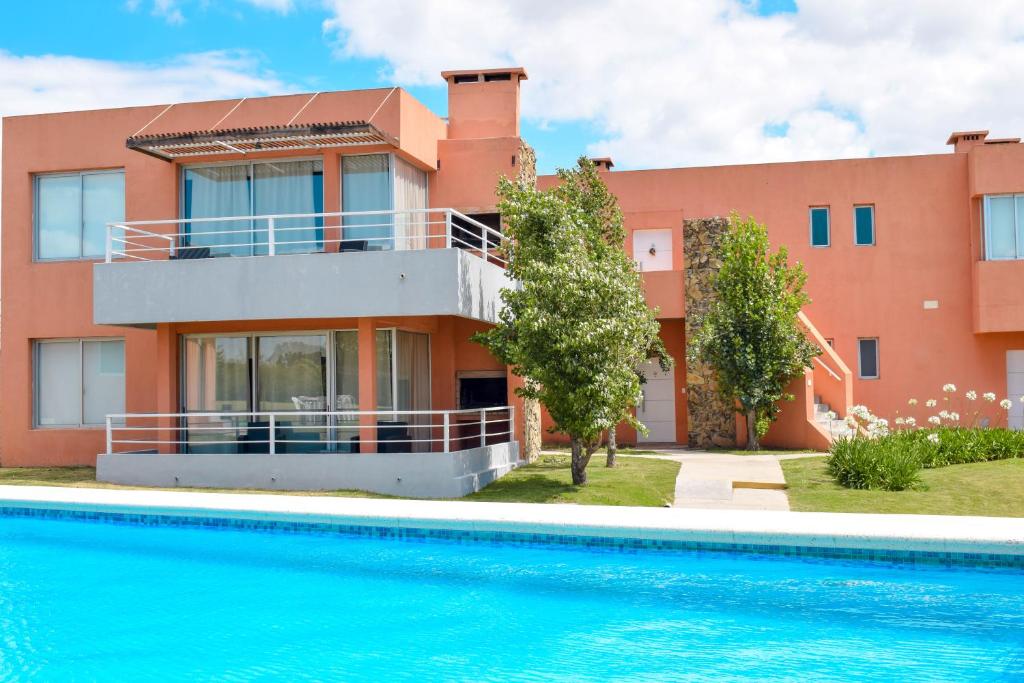 a house with a swimming pool in front of it at Lomas del Real Apart in Colonia del Sacramento
