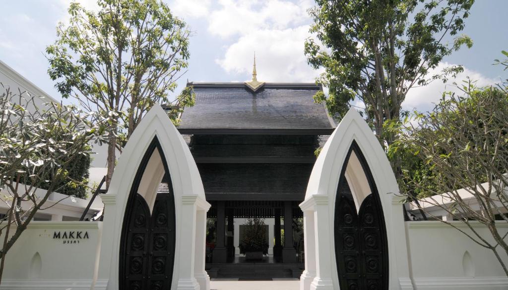 - l'entrée à un temple avec deux portes voûtées dans l'établissement Makka Hotel, à Chiang Mai
