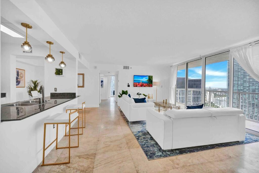 a living room with white furniture and large windows at 40th Floor Priceless Unit Central Location in Miami