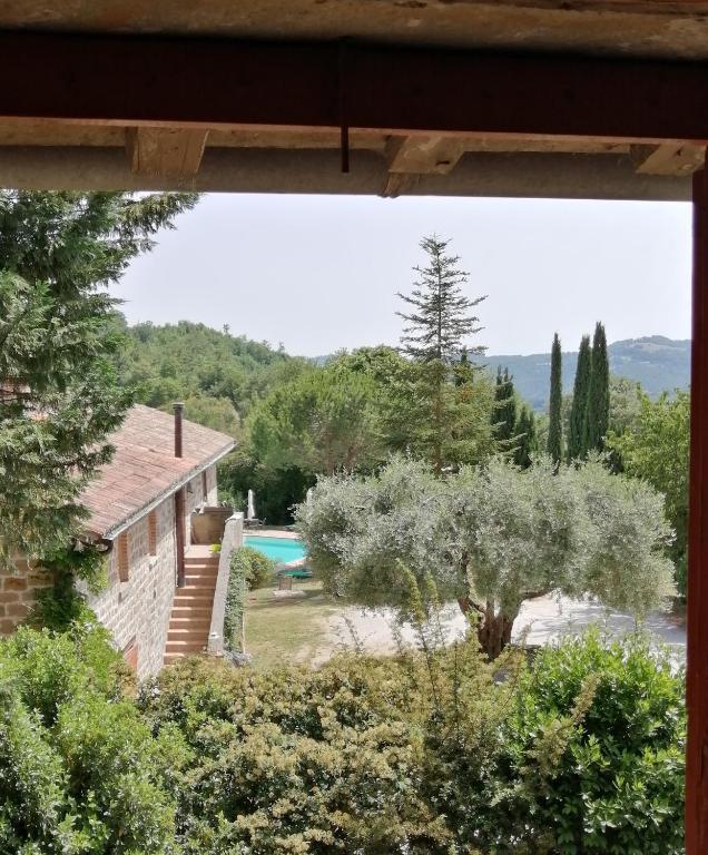 a view from a window of a house with a tree at La Brocca di Valdichiascio in Gubbio