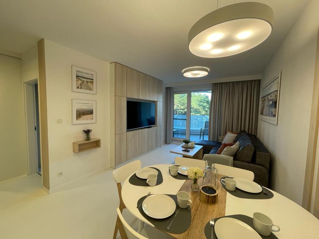 salon ze stołem jadalnym i kanapą w obiekcie Sunrise Apartament w Rogowie